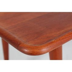 a close up of a wooden table with white wall in the backgroung