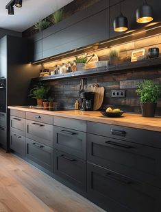 a kitchen with black cabinets and wooden counter tops, potted plants on the counters