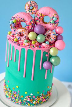 a birthday cake decorated with sprinkles and donuts