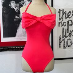 Take A Bow In A Pin-Up Worthy, Retro-Glam Design With This Geranium (Pinky-Coral) Bandeau Maillot One Piece Swimsuit. The Sweet Bow Detail Makes This Classic Suit A Must-Have. Fabric & Care Hand Wash Cold. Lay Flat To Dry. 84% Nylon/16% Spandex. Details One-Piece Maillot. Bandeau Neckline. Bow At Front Center. Removable Shoulder Straps. Removable Soft Cups. Fully Lined. Boning At Sides. Sizing & Fit Removable Straps Provide Extra Coverage. Removable Soft Cups For Extra Coverage And Shaping. Full Pink One-piece Swimwear For Party, Chic Pink Swimwear For Summer, Party Bandeau Swimwear For Beach Season, Spring Party Bandeau Swimwear, Bandeau Swimwear For Spring Party, Strapless Swimwear For Beach Party, Pink Party Swimwear For Spring, Strapless Party Swimwear For Beach Season, Strapless Summer Party Swimwear