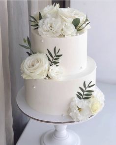 a three tiered cake with white flowers on top