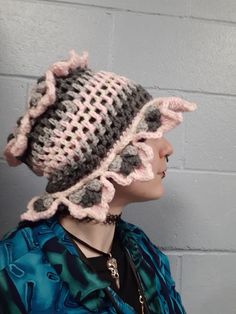 a woman wearing a crocheted hat with ruffles