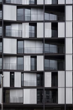 an apartment building with many windows and balconies on the side, all in black and white