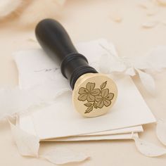 a rubber stamp with leaves on it sitting on top of some white paper next to a black ink pen