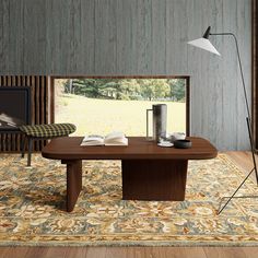 a living room with a large rug and wooden table in front of a window that has a book on it