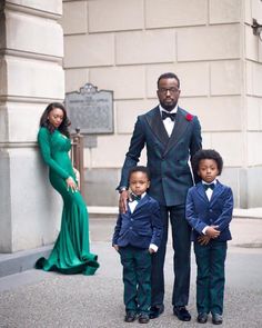 a man in a tuxedo poses with two children and an adult standing next to him