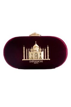 Oxblood oval-shaped clutch embellished with gold-toned Taj Mahal motif. Comes with a detachable chain.
Type: Embellished
Composition: Patent Metallic Leather; Lining: Quilted Silk Satin
Color: Oxblood - Maroon
Oval shaped
Size L (inch) : 8 x 4 x 2
Closure: Metal clasp - Aza Fashions Sabyasachi Collection, Gold Mandala, Bridal Clutch, Designer Clutch, Lakme Fashion Week, Satin Color, Textiles Fashion, Handbags Online, Online Fashion Stores