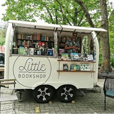 a man standing in front of a book truck with bookshelves on the side