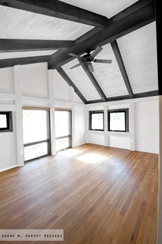 an empty room with wood floors and ceiling fan