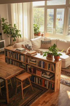 a living room filled with furniture and bookshelves next to a large open window