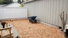 a dog is looking at something in the back yard that's full of wood chips