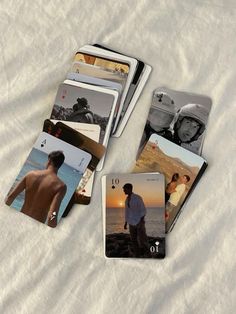 several cards with pictures of people on them laying on top of a white bed sheet