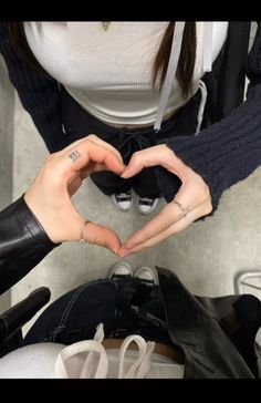 a woman making a heart shape with her hands