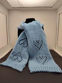 a blue knitted scarf sitting on top of a black table