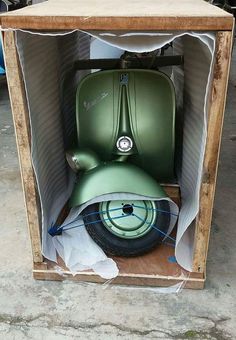 a green scooter in a cardboard box on the ground