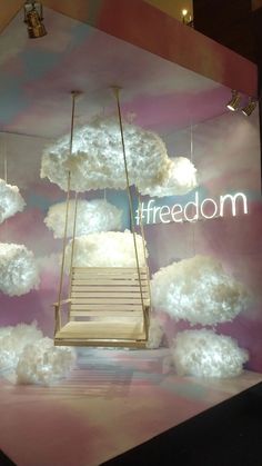 a display with clouds and a ladder in the middle that is suspended by strings above it