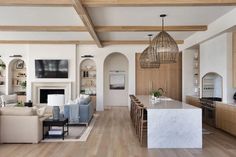 a living room filled with furniture and a fire place in the middle of a kitchen