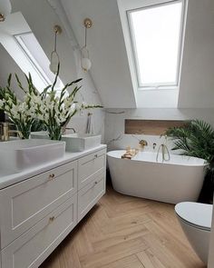 an attic bathroom with white fixtures and wood flooring