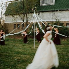 a bride and her bridal party in front of a house with white draping