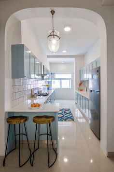 a kitchen with two stools next to an island