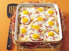 an egg dish with bacon and eggs on top in a white casserole pan