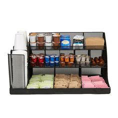 an assortment of food items is displayed on a black shelf with mesh bins for storage