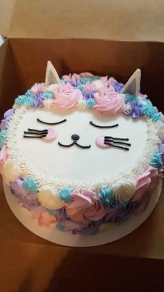 there is a cake that looks like a cat with flowers on the bottom and ears