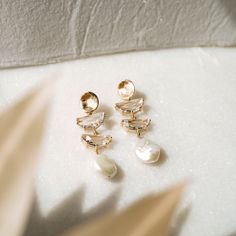 Our WREN Freshwater Pearl Earrings are so unique and drop dead gorgeous. Made with genuine freshwater pearl, they're made to stand out. They were designed for the classic, yet modern look. FEATURES Materials, Flat freshwater pearl, 14K Gold or Rhodium (silver) Wire-wrapped with 14k gold plated or sterling silver wire 100% nickel free, great for sensitive ears The pearls will vary in shape as they are natural and genuine Modern Pearl Earrings For Anniversary, Modern Pearl Charm Earrings For Wedding, Modern Pearl Drop Earrings For Wedding, Modern Pearl Earrings, Bridal Statement Earrings, Freshwater Pearl Earrings, Fan Earrings, Gold Pearl Earrings, Freshwater Pearls Earrings