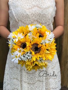 a bride holding a bouquet of sunflowers and daisies