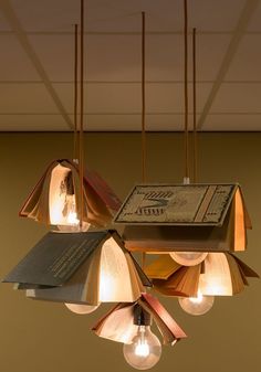 a chandelier with books hanging from it's sides and lights on the ceiling