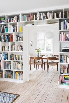 a room filled with lots of books and furniture