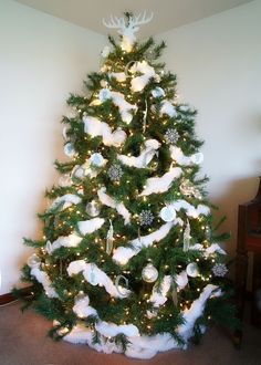 a decorated christmas tree with white and silver ornaments