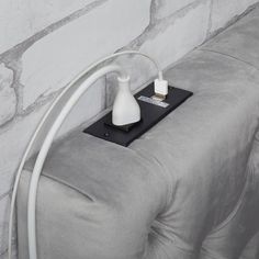 an electrical outlet plugged into a wall with a cord attached to it and a white light bulb on top