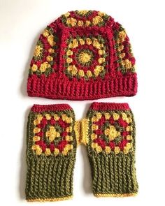 two crocheted mittens and gloves sitting on top of a white surface