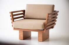 a chair made out of wood with a cushion on it's back and arms