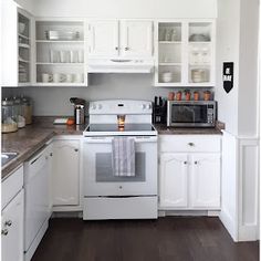 a kitchen with white cabinets and stainless steel stove top oven, microwave, dishwasher and coffee maker