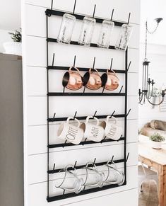 a wall mounted rack with cups and mugs on it