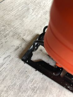 a close up view of a floor with a machine on it's side and an orange cone in the middle