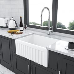 a white kitchen sink sitting next to a window