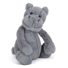 a gray stuffed animal sitting on top of a white floor