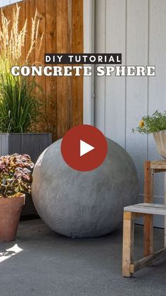 a concrete ball sitting on top of a patio next to potted plants and a wooden bench