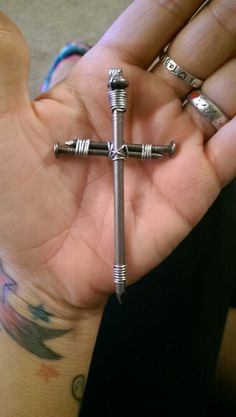 a person holding a metal cross in their hand