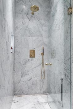 a walk in shower with marble walls and floor