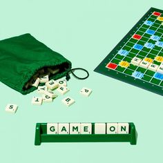 a scrabble game on a green table next to it's pouch