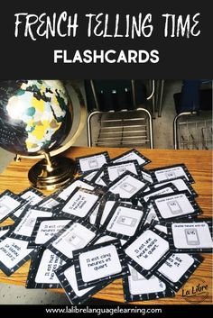 french telling time flashcards on a table with a globe and chair in the background