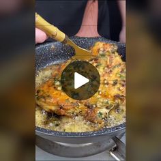 a pan filled with food on top of a stove next to a person holding a spatula