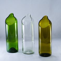 three different colored glass vases sitting next to each other