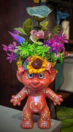 a flower pot with flowers in it on top of a table