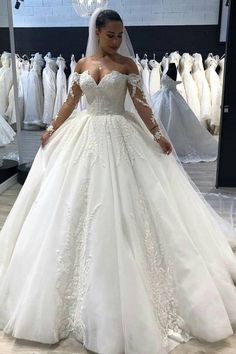 a woman standing in front of a wedding dress