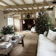 a living room filled with furniture and a christmas tree in the middle of the room